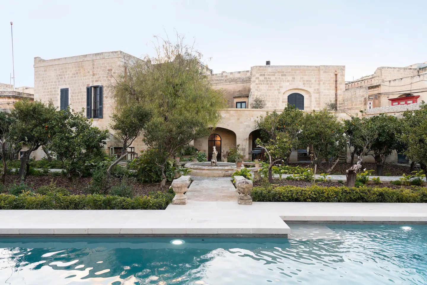 Casa de Piro's limestone exterior beside the garden and pool